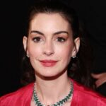 Anne Hathaway pasipuošia akinančiu kombinezonu ir batais iki šlaunų „Motinai